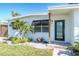 Close-up view of a home's front entrance, showcasing the well-kept lawn, garden and a modern black door at 4001 W North A St, Tampa, FL 33609