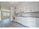 Bright kitchen featuring white cabinets, modern appliances, and granite countertops with gray wood floor at 4001 W North A St, Tampa, FL 33609