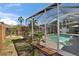 Screened-in patio with pool and backyard views with beautiful flowers and landscaping at 4017 3Rd E Ave, Bradenton, FL 34208