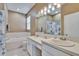 Spacious bathroom featuring dual sinks, a soaking tub, and elegant lighting fixtures at 4017 3Rd E Ave, Bradenton, FL 34208