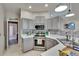 Updated kitchen with stainless steel appliances, gray cabinetry, granite countertops, and modern lighting fixtures at 4017 3Rd E Ave, Bradenton, FL 34208