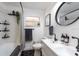 Modern bathroom with a double sink, shower and tub combo, and black fixtures at 4311 W Oklahoma Ave, Tampa, FL 33616