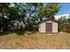 Backyard storage shed surrounded by mature trees and lawn at 4311 W Oklahoma Ave, Tampa, FL 33616