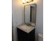 Modern bathroom vanity with dark wood cabinets, a light countertop, and a sleek mirror at 4410 19Th N St, St Petersburg, FL 33714