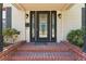 Front porch featuring a black door with decorative glass, brick steps, and black sconces at 4410 19Th N St, St Petersburg, FL 33714