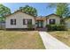 Charming single Gathering home with tan siding, black shutters, and a walkway leading to the front door at 4410 19Th N St, St Petersburg, FL 33714
