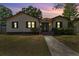 Charming single Gathering home with tan siding, black shutters, and a walkway at twilight at 4410 19Th N St, St Petersburg, FL 33714