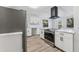 Modern kitchen featuring white cabinets, stainless steel appliances, and wood-look flooring at 4410 19Th N St, St Petersburg, FL 33714
