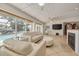 Bright living room featuring tile floors, ample seating, fireplace, and a view of an outdoor pool area at 4490 38Th S Way, St Petersburg, FL 33711