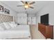Comfortable bedroom featuring a bed with tufted headboard, ceiling fan, dresser, and ensuite access at 4809 Walnut Ridge Rd, Land O Lakes, FL 34638
