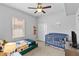 Bright bedroom featuring a blue crib, twin bed, and a ceiling fan at 4809 Walnut Ridge Rd, Land O Lakes, FL 34638
