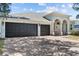 Home featuring a spacious three car garage and a brick paved driveway at 4809 Walnut Ridge Rd, Land O Lakes, FL 34638