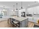 Bright kitchen features white cabinetry, stainless steel appliances, a large marble island with seating, and wood-look flooring at 4809 Walnut Ridge Rd, Land O Lakes, FL 34638