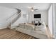 Bright living room features hardwood floors, a large sectional couch, and a staircase in a neutral decor at 4809 Walnut Ridge Rd, Land O Lakes, FL 34638