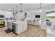 Open-concept kitchen and living room featuring hardwood floors, a large island, and a comfortable seating area with scenic views at 4809 Walnut Ridge Rd, Land O Lakes, FL 34638
