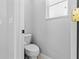 Neutral-toned powder room featuring a standard toilet and a small window at 4809 Walnut Ridge Rd, Land O Lakes, FL 34638