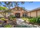 Inviting front entrance with brick archway, double doors, and lush landscaping at 4868 Lake Valencia E Blvd, Palm Harbor, FL 34684