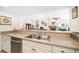 Kitchen view with granite countertops, neutral cabinets, stainless steel dishwasher and view to the living room at 4868 Lake Valencia E Blvd, Palm Harbor, FL 34684