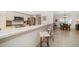 Open kitchen with stainless steel appliances, white cabinets, and a breakfast bar perfect for casual dining at 4868 Lake Valencia E Blvd, Palm Harbor, FL 34684