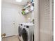 Functional laundry room equipped with appliances and shelving for organized storage at 4868 Lake Valencia E Blvd, Palm Harbor, FL 34684