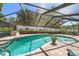 Screened in backyard pool with beautiful brick pavers and lush landscaping at 4868 Lake Valencia E Blvd, Palm Harbor, FL 34684
