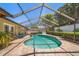 Beautifully landscaped screened in pool with brick pavers, lush gardens, and furniture at 4868 Lake Valencia E Blvd, Palm Harbor, FL 34684