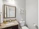 A compact bathroom with granite countertop, dark wood cabinet, and a decorative wall hanging at 5949 Parkset Dr, Lithia, FL 33547