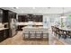 A spacious kitchen features an island with bar stool seating and stainless steel appliances adjacent to the dining room at 5949 Parkset Dr, Lithia, FL 33547