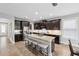 This open kitchen features dark wood cabinets, a stainless steel fridge, and a large island with seating at 5949 Parkset Dr, Lithia, FL 33547