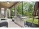 Relaxing covered patio with grill, fan, neutral stone tile, and views of the backyard at 5949 Parkset Dr, Lithia, FL 33547
