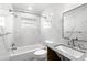 Bathroom with white marbled tiles, bathtub, and updated fixtures at 624 Orange St, Palm Harbor, FL 34683