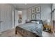 Serene bedroom with gray bedding, framed botanical prints, and a glimpse into an adjacent dining area at 6301 Marbella Blvd, Apollo Beach, FL 33572