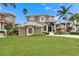 Charming two-story home with well-manicured lawn and lush landscaping creates an inviting curb appeal at 6301 Marbella Blvd, Apollo Beach, FL 33572