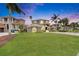 Exterior front view of a two-story home, showcasing a large green lawn, a gray facade, and a driveway at 6301 Marbella Blvd, Apollo Beach, FL 33572