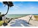 Scenic view of the jetty leading to the ocean with a palm tree and warning sign at 6301 Marbella Blvd, Apollo Beach, FL 33572