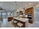 Spacious kitchen featuring a center island with seating, stainless steel appliances, and wooden cabinetry at 6301 Marbella Blvd, Apollo Beach, FL 33572