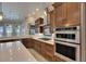 Close up of the kitchen featuring a gas cooktop, stainless steel appliances and wooden cabinets with under cabinet lighting at 6301 Marbella Blvd, Apollo Beach, FL 33572