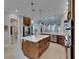 Well-lit kitchen with stainless steel appliances, large island with seating and wood cabinetry with a tile floor at 6301 Marbella Blvd, Apollo Beach, FL 33572
