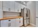 Kitchen featuring stainless steel refrigerator, white cabinets, wood counters and white tiled backsplash at 6301 Marbella Blvd, Apollo Beach, FL 33572