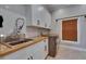 Well-organized laundry room with a utility sink, butcher block countertop, and a modern washer and dryer set at 6301 Marbella Blvd, Apollo Beach, FL 33572