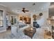 Inviting living room with a ceiling fan, seamless access to the kitchen and outdoor dining area, and neutral decor at 6301 Marbella Blvd, Apollo Beach, FL 33572