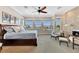 Spacious bedroom with multiple windows, sitting area, stone fireplace and ceiling fan at 6301 Marbella Blvd, Apollo Beach, FL 33572