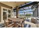 Covered patio with dining area, lounge seating, and views of the pool and serene backyard at 6301 Marbella Blvd, Apollo Beach, FL 33572