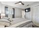 Comfortable bedroom with a large window, a ceiling fan, and a closet with bi-fold doors at 6529 Thicket Trl, New Port Richey, FL 34653