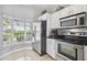 Bright kitchen with stainless steel appliances, white cabinetry, and tile flooring at 6529 Thicket Trl, New Port Richey, FL 34653