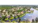 Wide aerial shot showcasing a community with waterfront homes on a tranquil lake surrounded by lush greenery at 772 Live Oak Ne Ter, St Petersburg, FL 33703