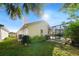 Landscaped backyard with screened in patio, mature trees, and lush lawn at 772 Live Oak Ne Ter, St Petersburg, FL 33703