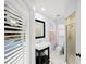 Stylish bathroom with vanity, mirror and tiled shower with glass door; backyard pool view through window at 772 Live Oak Ne Ter, St Petersburg, FL 33703