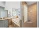 Luxurious bathroom with a soaking tub, glass block window and walk-in shower featuring neutral tile at 772 Live Oak Ne Ter, St Petersburg, FL 33703