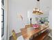 Bright dining room featuring a large window, wood floors, a long wooden table, and modern chandelier at 772 Live Oak Ne Ter, St Petersburg, FL 33703